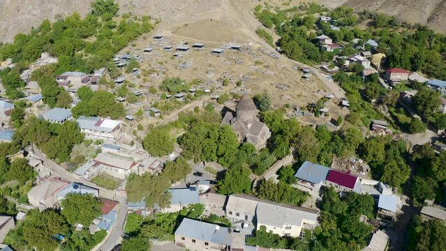 Forward reveal aerial shot of Surb Astvatsatsin Church on sunny summer day. Bjni village, Kotayk Province, Armenia.