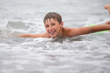 The face of a happy boy who swims in the sea.