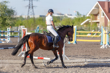 Young rider woman riding horse warming up before showjumping competition