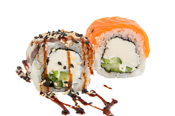 Sushi with rice and Philadelphia cheese trout, sprinkled with sesame seeds and poured with soy sauce. Sushi on a white background close-up.