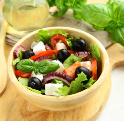 Greek salad with olives in a wooden bowl
