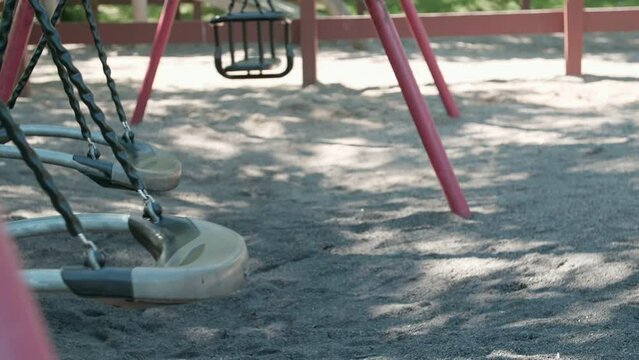 Close up of empty swing set swaying in suburb Botkyrka, Stockholm. 