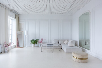 interior of a bright living room in a luxurious baroque style with white walls decorated with...