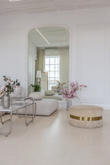 interior of a bright living room in a luxurious baroque style with white walls decorated with antique stucco