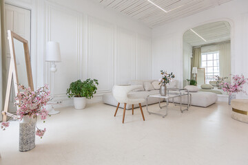 interior of a bright living room in a luxurious baroque style with white walls decorated with antique stucco