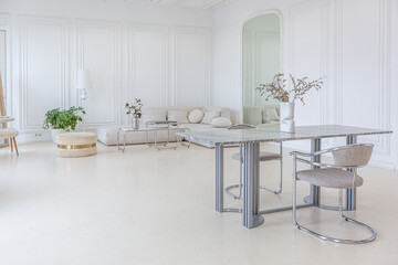 interior of a bright living room in a luxurious baroque style with white walls decorated with antique stucco