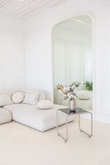interior of a bright living room in a luxurious baroque style with white walls decorated with antique stucco