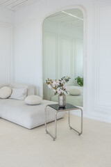 interior of a bright living room in a luxurious baroque style with white walls decorated with antique stucco