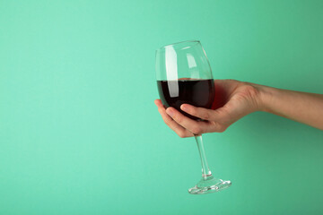 Young girl holding glass of tasty red wine on pink background. Space for text