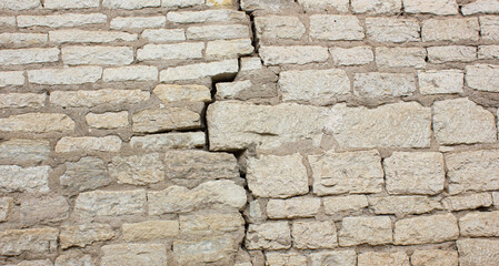 Crack in a brick wall. Cracked stone wall.