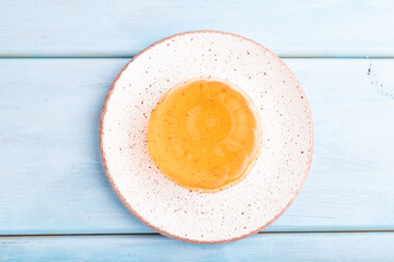 Apricot orange jelly on blue. top view.