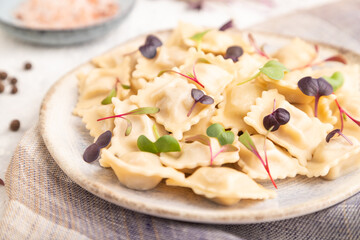 Dumplings with pepper, herbs, microgreen on gray concrete. Side view, selective focus.