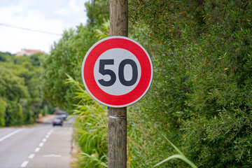 Speed limit sign 50 kilometers per hour at Giens Peninsula on a cloudy late spring day. Photo taken...