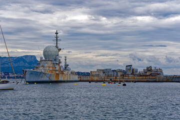 Moored war ships at French Navy Naval Base at City of Toulon on a cloudy late spring day. Photo...