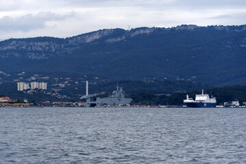 Moored warships at French Navy Naval Base at City of Toulon on a cloudy late spring day. Photo...