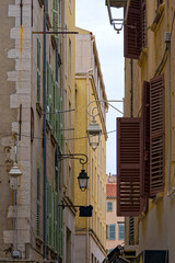 Narrow alley with facades of historic houses at French City of Toulon on a cloudy late spring day. Photo taken June 9th, 2023, Toulon, France.