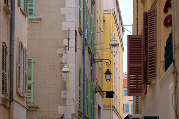 Narrow alley with facades of historic houses at French City of Toulon on a cloudy late spring day....
