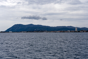 Bay of Mediterranean Sea with skyline of French City of Toulon on a cloudy late spring day. Photo taken June 9th, 2023, Toulon, France.