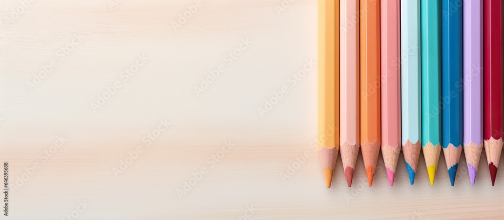 Poster color pencils are positioned in front of a isolated pastel background copy space