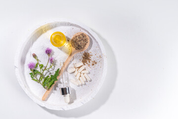 Milk Thistle supplies, powder and oil. Silybum marianum, natural organic wild flower superfood product - whole and grain seeds, pills, oil with fresh thistle flowers