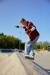 Teenager guy with roller skates performing tricks outdoors