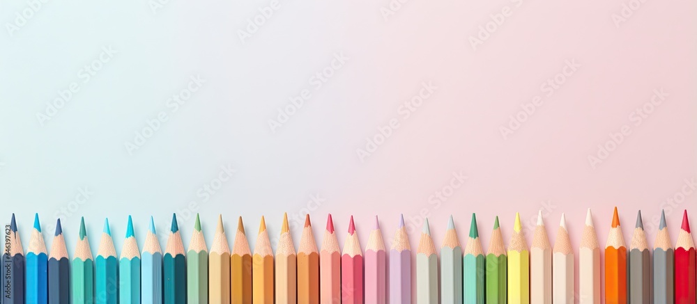 Poster color pencils are positioned in front of a isolated pastel background copy space