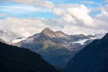 View of mountain peak surrounded by clouds in Alaska, USA.