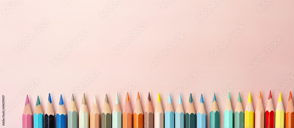 Poster color pencils are positioned in front of a isolated pastel background copy space