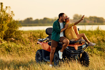 A happy couple in love taking a selfie on a quad bike, having a great time.