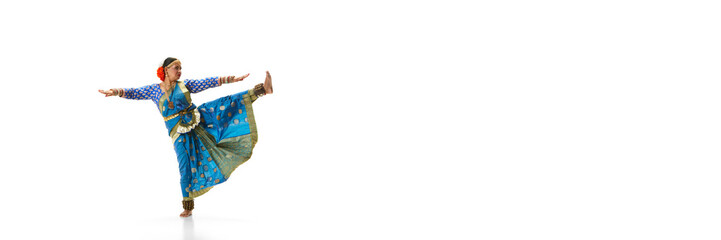 Artistic indian woman in traditional dress dancing indian dance against white studio background. Concept of beauty, fashion, India, traditions, lifestyle, choreography, art. Copy space for ad. Banner
