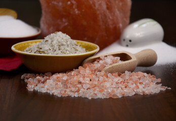 Himalayan pink salt stock images. Salt and wooden scoop still life stock photo. White, pink and herb table salt stock images