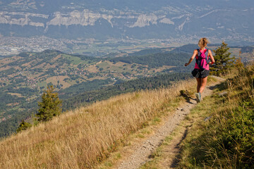 Fototapeta premium ST-AGNES, FRANCE, August 24, 2023 : Young woman runner trains on slopes of Belledonne before the ultra-trail that crosses the mountain range