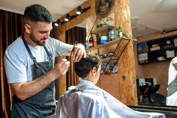 A little boy getting a haircut at the barber shop
