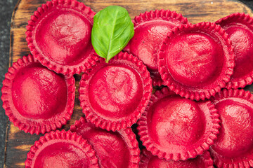 ravioli red color beet dye radicchio and meat filling smoked ham Cooking appetizer meal food snack on the table copy space