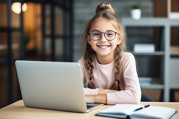 A schoolgirl sits at home with her laptop computer. Girl smiling, online education, learning and courses for children concept.
