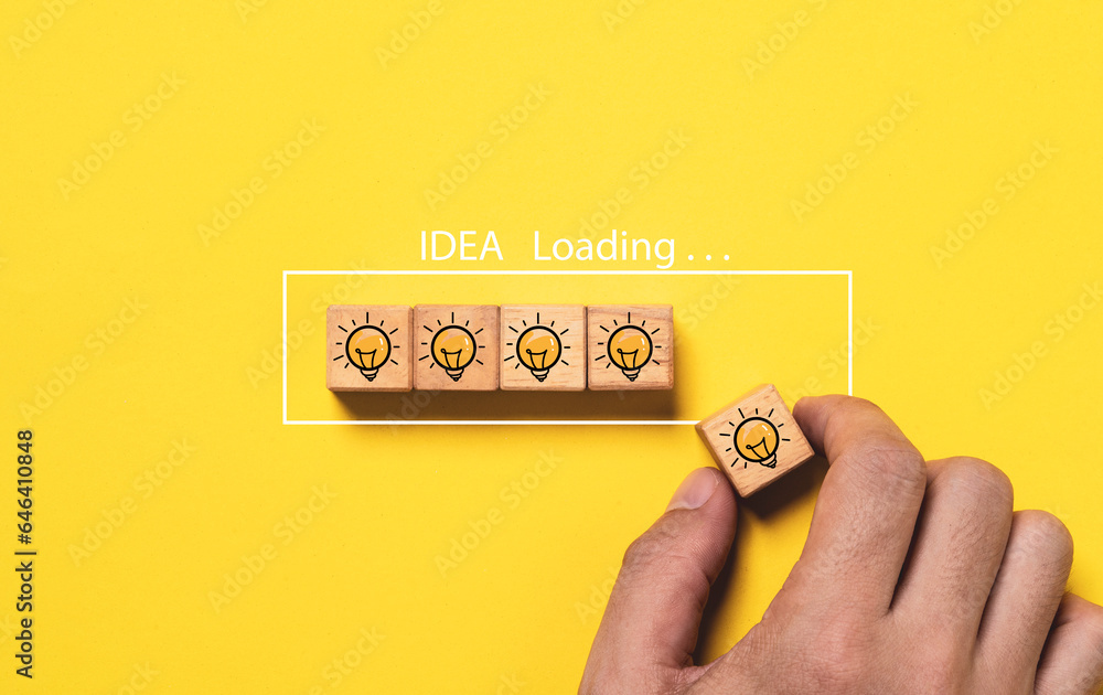 Poster hand assembly glowing lightbulb drawing on wooden block cube to update of downloading bar on yellow 