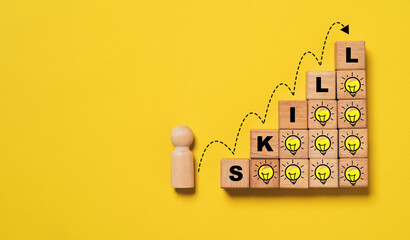 Wooden figure with jump diagram on wooden step and glowing lightbulb and skill wording for human...