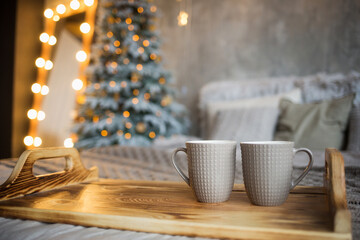 new year product mockup. cozy holiday decoration of house: Christmas tree, bed, garland with stars, tray with couple of cups and copy space. home decor