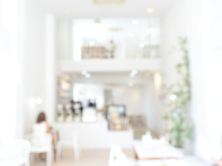 Abstract blurred modern cafe background, white indoor interior of minimal white coffee shop with lighting and decoration furniture. Blurry backgrounds for advertising and business presentation.