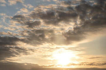 Naklejka na ściany i meble Dramatic sky, sun shining through dark clouds at dawn