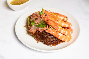 Shrimp potted with vermicelli; dipping black vinegar sauce or spicy seafood sauce. Main Ingredient is glass noodle, coriander roots, pepper, garlic, ginger and shrimp.