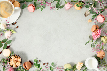 Coffee time concept. Frame made of Spring flowers, different types of macaroons and coffee flat lay