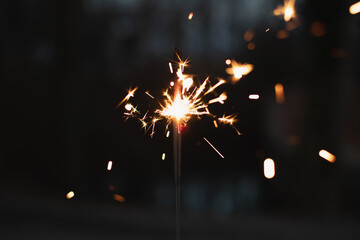 Obraz premium photography, sparkler close-up on a dark background, holiday lights 