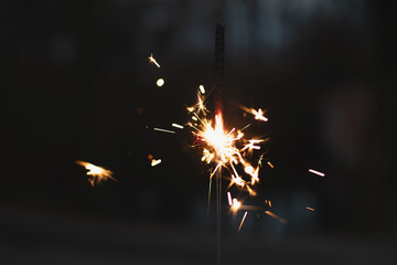 Obraz premium photography, sparkler close-up on a dark background, holiday lights 