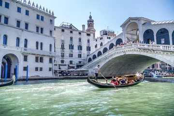 Stickers pour porte Gondoles a gondola passes under the Rialto Bridge in Venice