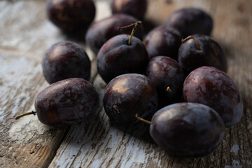 Ripe plums on a wooden old background, horizontal format, macro