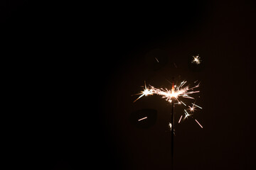 photography, sparkler close-up on a dark background, holiday lights