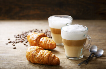 glasses of latte macchiato coffee and croissants