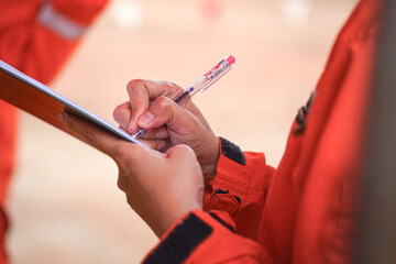 Action of an engineer is writing to take note during perform job planning and brainstorm meeting at the construction working site. Industrial working and teamwork, selective focus.