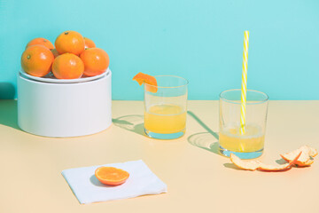 Peeled tangerine and juice glass with slice and straw. Concept Patty. The background is beige and birch.